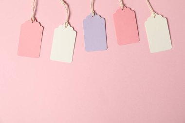 Pembe arka planda ipleri olan boş etiketler, düz yatış. Metin için boşluk
