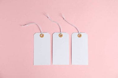 Pembe arka planda dizgileri olan boş etiketler, düz uzanma