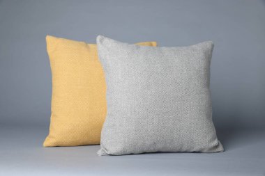 Gri arkaplanda iki yumuşak dekoratif yastık