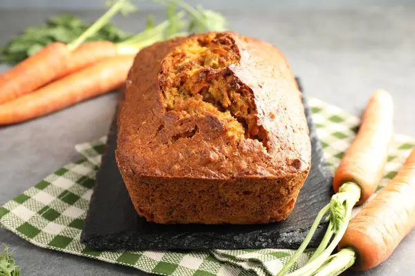 Gri desenli masada havuçlu kek ve sebzeler, yakın plan.