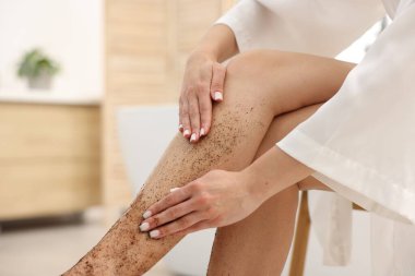 Kadın bacağını içeride ovuyor, yakın plan.