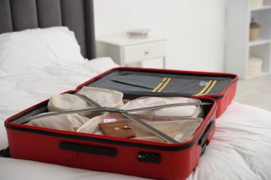 Paketleme küpleri ve pasaport biletleri bavulun içinde yatağın içinde, yakın plan.