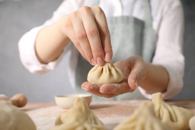 Mutfaktaki masada khinkali yapan kadın, yakın plan.