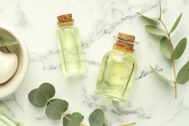 Beyaz mermer masa üzerinde gerekli yağ, okaliptüs yaprakları, harç ve tokmak şişeleri, düz yatıyordu.