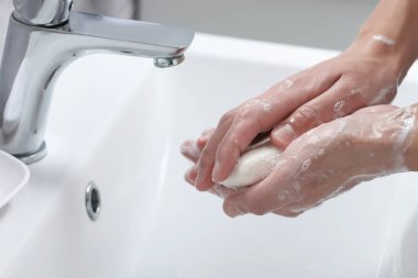 Ellerini banyoda sabunla yıkayan kadın, yakın plan.