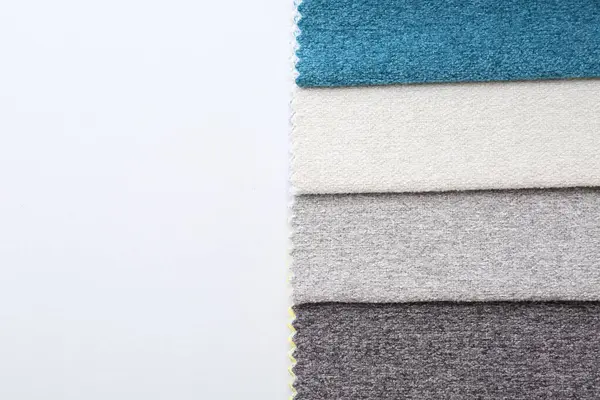 Beyaz arka planda farklı kumaş örnekleri, üst manzara. Metin için boşluk