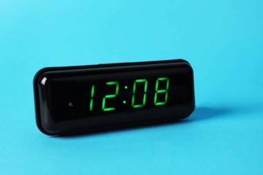 Açık mavi arkaplanda saat 12: 08 'i gösteren dijital alarm saati