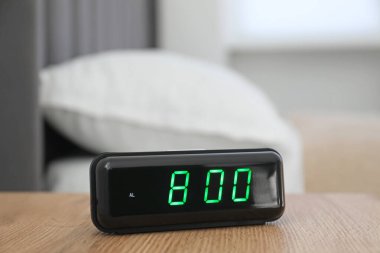 Dijital alarm saat 8 'de kapalı bir masada.