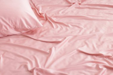 Yatakta güzel pembe ipek çarşaflar, yakın plan