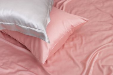 Yatakta güzel pembe ipek çarşaflar. Metin için boşluk