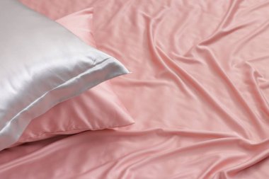 Yatakta güzel pembe ipek çarşaflar. Metin için boşluk