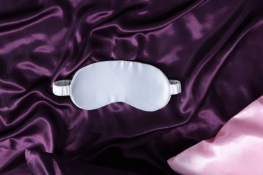 Lüks ipek çarşaflar ve uyku maskesi, üst manzara.