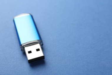 Mavi arka planda bir flaş bellek, yakın plan. Metin için boşluk