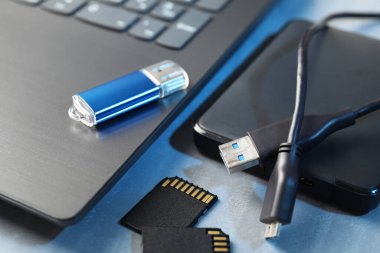 Flaş bellek, SD hafıza kartları, harici sabit disk ve dizüstü bilgisayar gri masada, yakın plan