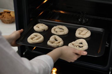 Pişmemiş krakerlerle fırına yemek koyan kadın, yakın plan.