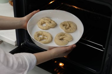 Pişmemiş krakerlerle fırına yemek koyan kadın, yakın plan.