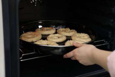 Pişmemiş krakerlerle fırına yemek koyan kadın, yakın plan.