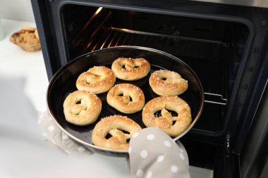 Fırından taze krakerlerle fırın yapan kadın, yakın plan.