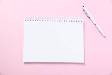Pembe arka planda boş defter ve kalem aç, düz yat