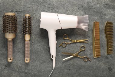 Gri dokulu arka planda farklı saç şekillendirme araçları, düz yatış