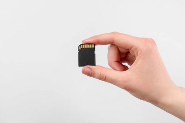 Hafıza kartı açık gri arka planda olan adam, yakın plan. Metin için boşluk