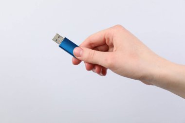 Açık gri arka planda modern flash diski olan adam, yakın plan.