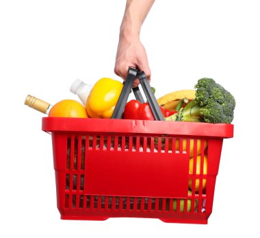 Beyaz arka planda farklı ürünleri olan alışveriş sepeti tutan adam, yakın plan.