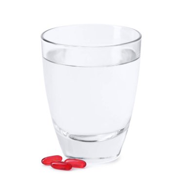 Kolajen kapsülleri ve beyaz üzerine izole edilmiş bir bardak su.