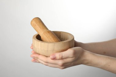 Hafif arka planda havan topu ve tokmağı olan kadın, yakın plan.