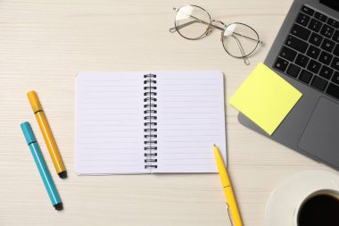 Not defteri, yapışkan not, kalem, keçeli kalem, kahve, bardak ve dizüstü bilgisayar ahşap masa, düz yatıyordu.