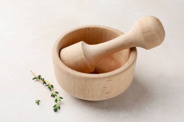 Tahta havan topu, tokmak ve kekik beyaz masada, yakın plan