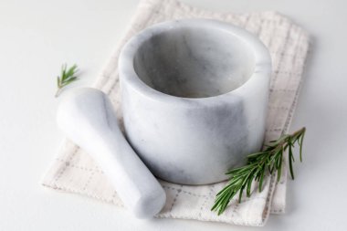 Biberiyeli mermer havan topu, beyaz masa üzerinde tokmak ve kumaş, yakın plan.