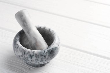 Mermer harç ve tokmak beyaz ahşap masa üzerinde, yakın çekim. Metin için boşluk