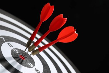 Hedef alınıyor. Siyah arkaplanda okları olan dart tahtası, yakın plan