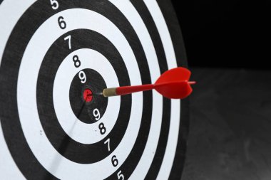 Hedef alınıyor. Karanlık arkaplanda ok olan dart tahtası, yakın plan