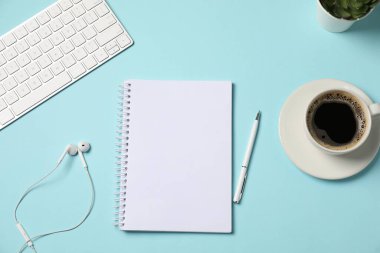Not defteri, kalem, kulaklık, kahve ve bilgisayar klavyesi açık mavi arka plan, düz uzanma