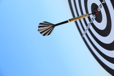 Hedef alınıyor. Mavi gökyüzüne karşı oklu dart tahtası, yakın plan.