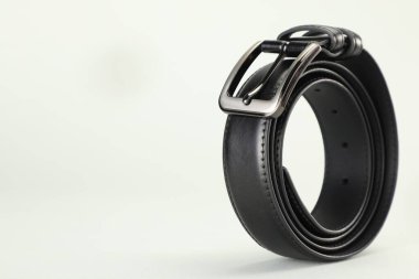 Beyaz arka planda siyah deri bir kemer, yakın plan. Metin için boşluk