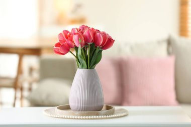 Beyaz masadaki vazodaki güzel laleler