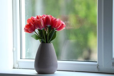 Pencere pervazında vazodaki güzel laleler. Metin için boşluk