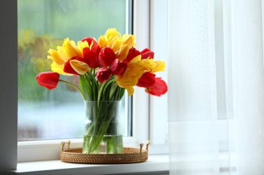 Pencere pervazında vazodaki güzel laleler