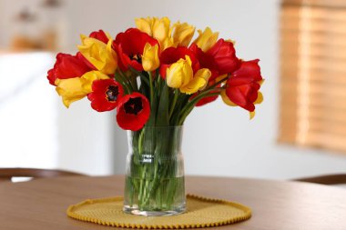 İçerideki ahşap masada vazodaki güzel laleler.