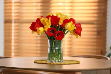 İçerideki ahşap masada vazodaki güzel laleler.