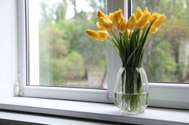 Pencere pervazında vazodaki güzel laleler. Metin için boşluk