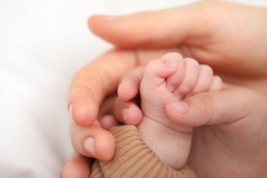 Anne, küçük bebeği evde, yatağında, yakın plan.