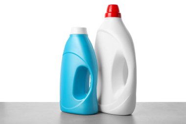 Beyaz arkaplana karşı gri masada yumuşatıcı şişeler