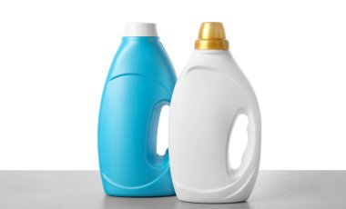 Beyaz arkaplana karşı gri masada yumuşatıcı şişeler