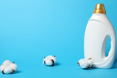 Açık mavi arkaplanda yumuşatıcı ve pamuk çiçekleri, metin için boşluk