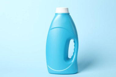 Açık mavi arkaplanda bir şişe yumuşatıcı