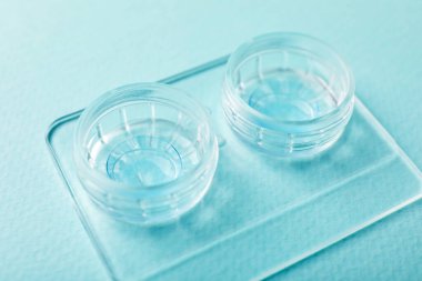 Açık turkuaz arka planda kontak lensleri, yakın plan